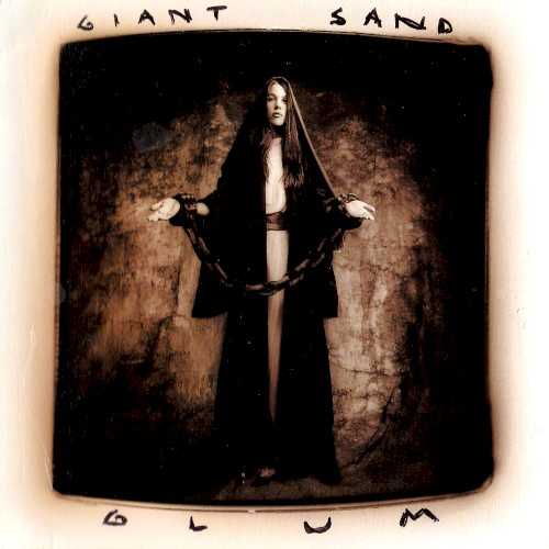 Allmusic album Review : Glum, the 10th record by Arizona-based Giant Sand, was released in 1994. Main man Howie Gelb and his revolving cast of backing musicians were produced by Daniel Lanois protégée Malcolm Burn for this effort. Gelbs vocals have a nasally, offhand quality that is similar to those of Flaming Lips Wayne Coyne. The music is a blend of rock, folk, and country with some high-octane, gloriously dissonant twists. The title track is a fine example as the simple acoustic-based melody gives way to bursts of mangled guitar. "Yer Ropes" is a chaotic swirl of noise with organ by Burn and slide guitar courtesy of Peter Holsapple. Theres also several lovely slower tracks like the piano ballad "Spun," to which Victoria Williams adds vocals, and "Left," which has a wistful country feel. Glum is the sound of the Southwestern desert committed to disc and a rollicking album.