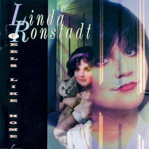 Allmusic album Review : Linda Ronstadts 1995 album, Feels Like Home, was a return to her country-rock roots, resulting in an album much more "down-home" and less glossy than her previous pop albums, Winter Light and Cry Like the Rainstorm, Howl Like the Wind. Less glossy production isnt necessarily a bad thing, except that the final result is an album that is top-quality but a little bland. Ronstadts voice is nothing short of stellar, and the songs are fine, but there is a certain immediacy that is lacking in this album, especially toward the end, when it just seems to drift. Then again, with a "down-home" album, that may have been the point. Regardless, this album boasts her usual array of stellar covers, including her fine, mandolin-accompanied take on Tom Pettys "The Waiting," in which Ronstadts enunciations are highly reminiscent of Pettys. Her rendition of Matraca Bergs "Walk On," complete with Alison Krauss on fiddle, is nothing short of an out-and-out hoedown, and her version of Neil Youngs "After the Gold Rush" is quite enjoyable. Five of these songs -- "High Sierra," "The Blue Train" (the albums first single, which is pure AC), "Feels Like Home," "After the Gold Rush," and "Lovers Return," most of which feature Emmylou Harris -- all resurfaced on the Trio II album. Just like any other Ronstadt set, this is top-quality material, but one cant help but pine for the punch and perfect production of her previous pop packages.