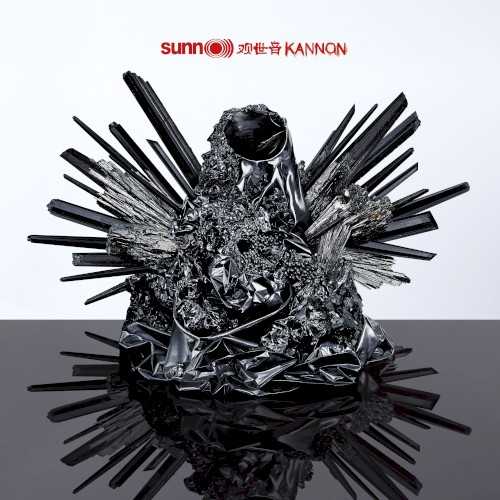 Allmusic album Review : When is nothing something? When is empty full? Kannon, Sunn O)))s first "solo" project since 2009s Monoliths & Dimensions, poses these questions sonically. Stephen OMalley and Greg Anderson enlisted old friends to assist: Co-producer Randall Dunn (who also plays synths), vocalist Attila Csihar, guitarist Oren Ambarchi, percussionist Brad Mowen, Rex Ritter on Moog, and a brass trio that includes Julian Priester, Stuart Dempster, and Tony Moore. The album title is named for the feminine Buddhist deity of mercy, Kanon (or Quan Yin), who "perceives all the sounds and cries of the world." (In the Tibetan male form, she is the bodhisattva Avalokiteśvara, who embodies the compassion of all Buddhas.) Kannon is structured as a three-part, numbered "triadic whole." Artist and theorist Aliza Shvarts, in her lengthy, soundly argued liner essay, describes them thusly: "Kannon 1": Invocation, "Kanon 2": Intonation, and "Kanon 3": Perpetuation. She brilliantly argues the question: "What is metal about mercy?" and proceeds to critique the notion of metals power as not merely penetrative but immersive -- this album is most certainly the latter. "Kanon I" offers Andersons earth quaking bass in full, dirty drone as OMalleys guitar repeats an ascending and descending three-note pattern. Csihar whispers, groans, and quietly growls poetic lyrics inspired directly by the Buddhist legend so elastically and deliberately, they are almost impossible to distinguish. Emanating from a wall of white noise, they entwine their heaviness with layers of massive ambient sound from synths and low brass. "Kannon 2" commences with squalling guitar feedback and raw, single guitar notes played in a pattern of four that repeat in reverse "choruses." The overblown bass drone enters at two-and-a-half minutes, and Csihar delivers his lyrics first in a Gregorian chant style that represents a "canonical" or traditional structure which, as Shvarts critiques, is itself a linguistic term that equates with Western male power structures. But Csihar then shifts (effortlessly) to Eastern throat singing, a folk style shared by sheepherders and monks alike. Sunn O))) turn the musics amplified power back on itself to allow his voices not only presence but fluidity. That cooperative flow is broken by the sound of a violent explosion that gives way to a sarod-esque drone. The effect is unsettling. "Kannon 3" is a studio version of "Canon" from 2008s live album Dømkirke. OMalleys piercing two-note theme harmonically registers with the powerful synth and a rumbling bassline. Along with waves of controlled noise, Csihars guttural vocal builds with the music until hes shrieking apocalyptically. The instrumental attack remains nearly glacial while its intensity increases exponentially. Large swathes of formless noise flow through the crashing waves until a final swell of feedback consumes it all until it blacks out. On Kannon, Sunn O))) illustrates through heavy sonic immersion that noise and silence are equals -- aspects of circular, self-perpetuating emptiness. Like the persona of the deity, they generously receive and contain all the sounds of the world in all their dimensions of darkness and light.